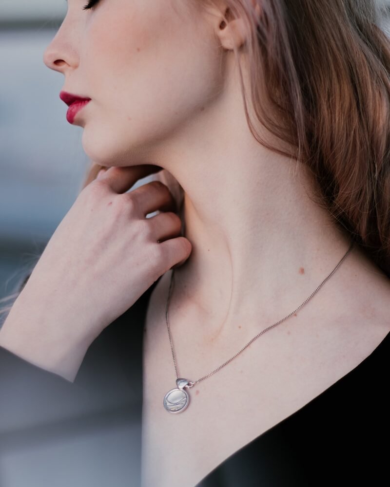 woman in black shirt wearing silver necklace